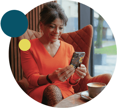 Mature woman reading her mobile phone while drinking coffee